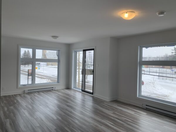 Appartement lumineux avec deux chambres à Mirabel secteur St-Canut, disponible à partir du 1er juillet, offrant un espace moderne et confortable avec grandes fenêtres et vue sur la neige.
