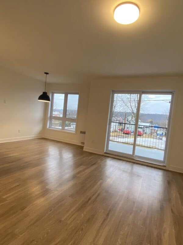 Grand appartement avec salon spacieux, lumière naturelle et accès au balcon. Parfait pour gestion immobilière et location résidentielle.