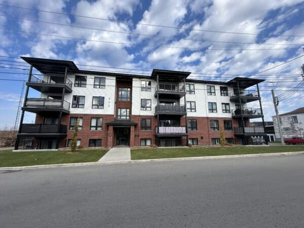 Immeuble résidentiel contemporain avec gestion immobilière professionnelle, espaces extérieurs soigneusement entretenus, idéal pour placement locatif ou résidence principale.