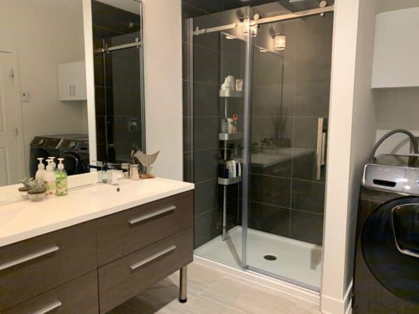 Salle de bain avec douche élégante et commodités pratiques pour la gestion immobilière.