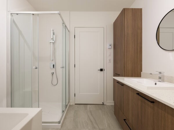 Salle de bain avec douche en verre et mobilier en bois.