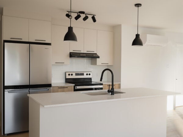 Cuisine moderne avec îlot central dans un appartement de 2 chambres à Joliette, offrant un espace lumineux et fonctionnel, idéal pour la gestion immobilière et la location.