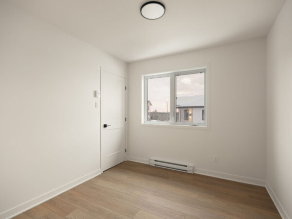 Chambre lumineuse avec fenêtre dans un appartement de deux chambres à Brownsburg-Chatham, idéal pour une gestion immobilière efficace.