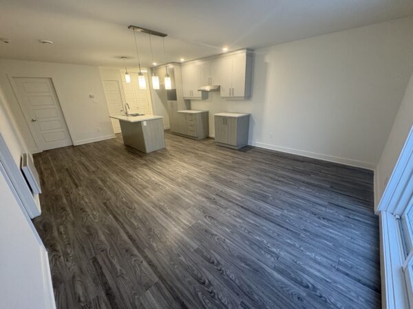 Vue intérieure d'un appartement moderne avec cuisine équipée, deux chambres spacieuses, idéal pour location à Lachute, prêt à emménager.