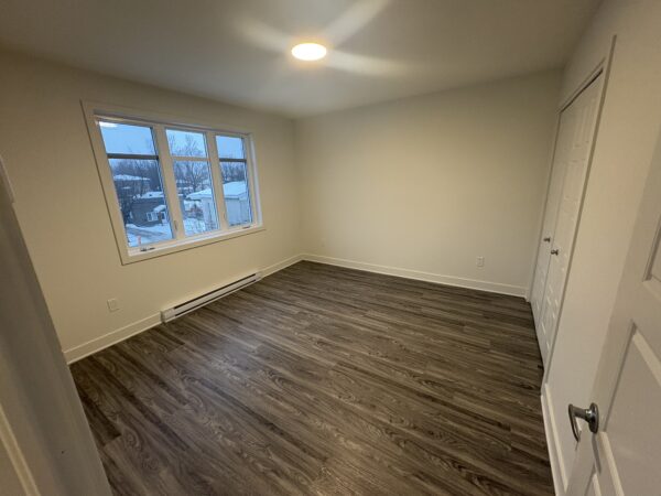 Appartement lumineux avec grandes fenêtres offrant une vue sur la ville et un intérieur moderne. Parfait pour un logement confortable et pratique à Lachute.
