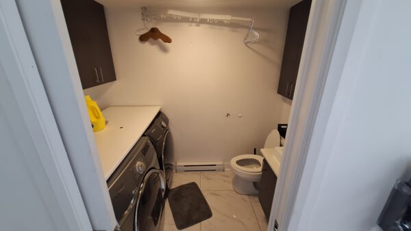 Vue intérieure d'un appartement de 3 chambres à louer à Saint-Calixte, avec buanderie, toilettes et espace de rangement, idéal pour famille ou professionnels.