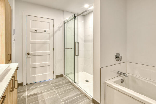 Appartements 3 chambres à Saint-Charles-Borromée - Salle de bain moderne avec douche en verre et baignoire, offrant confort et style dans un logement spacieux.