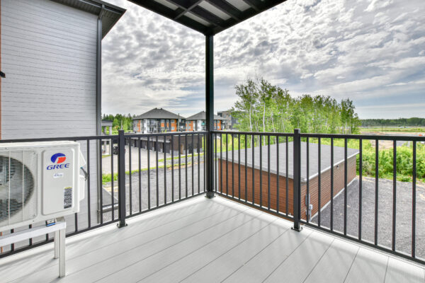 Balcon spacieux avec vue dégagée sur le quartier résidentiel de Saint-Charles-Borromée, idéal pour profiter de l'extérieur en toute tranquillité.