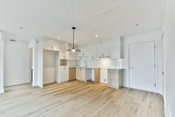 Vue intérieure d'un appartement moderne de 3 chambres à Saint-Charles-Borromée, avec cuisine lumineuse, plancher en bois clair et espace de vie spacieux.