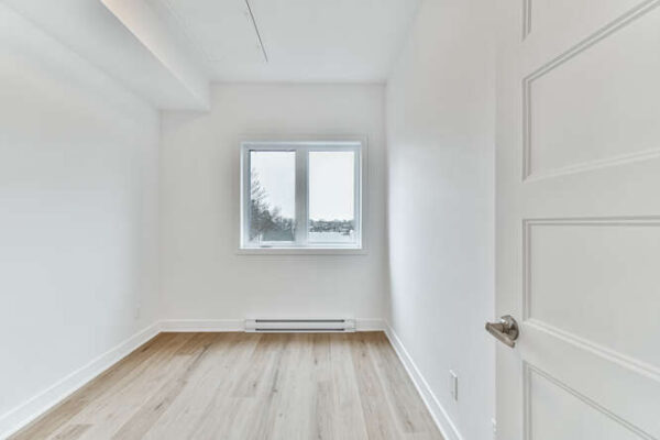 Appartement lumineux avec fenêtre double vitrage et plancher en bois.
