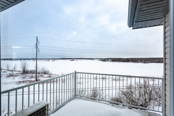 Balcon privé offrant une vue dégagée sur un paysage enneigé, idéal pour profiter de l'hiver et de la tranquillité dans un appartement à Crabtree, disponible en juillet.