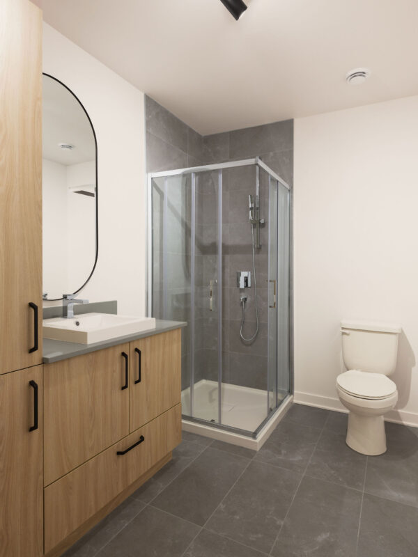 Balcon avec vue sur la ville, intérieur moderne et lumineux, salle de bain équipée, parfait pour famille ou professionnels.