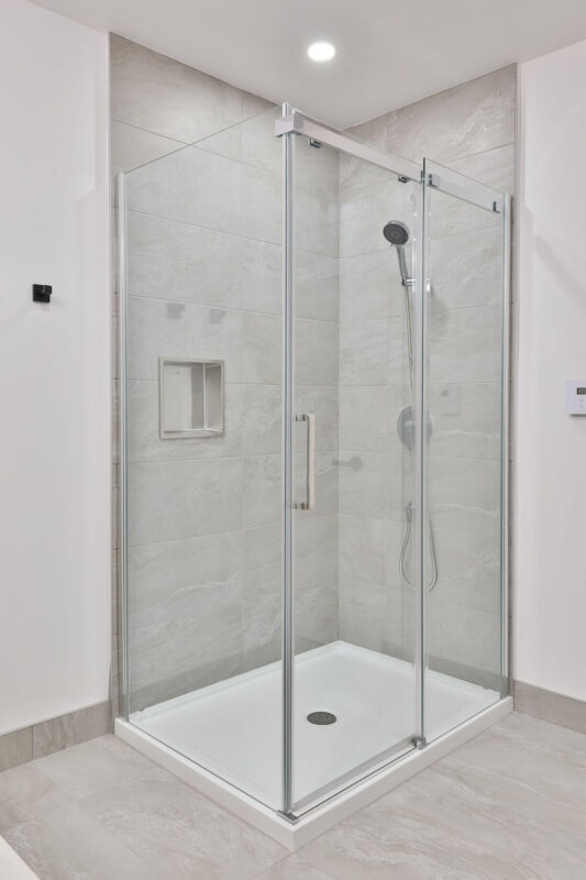 Vasque de douche en verre dans un appartement de Mirabel, idéal pour la gestion immobilière. Conception élégante et fonctionnelle, parfaite pour un logement de qualité en juillet.
