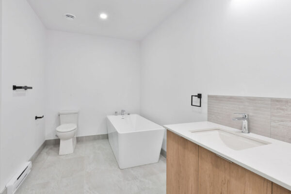 Appartement 2 chambres moderne à Mirabel, parfait pour une famille ou un couple, avec salle de bain élégante, baignoire et espace de rangement.