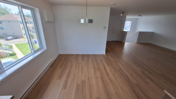 Vue intérieure d'un appartement lumineux avec deux chambres à louer à Saint-Lin, parfait pour un logement confortable en juillet.