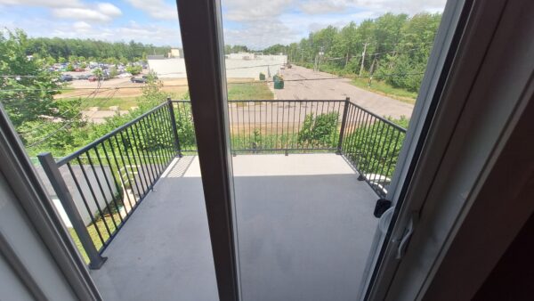 Balcon privé avec vue dégagée sur parking et espaces verts, idéal pour profiter du plein air à Saint-Lin.