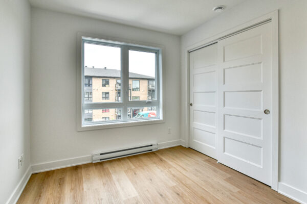 Appartement lumineux avec grande fenêtre et espace de rangement.