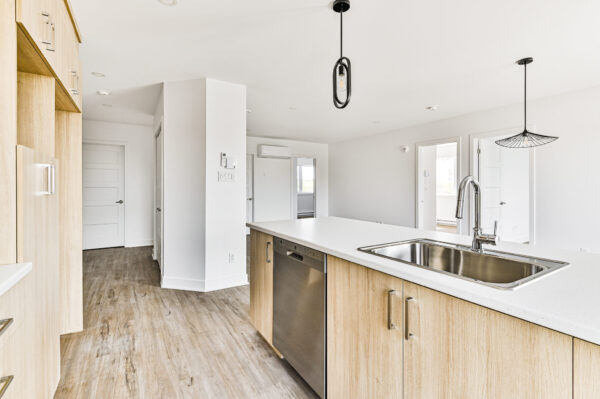 Appartement lumineux avec cuisine moderne et espace ouvert à Sainte-Julienne, parfait pour une vie confortable en juillet.