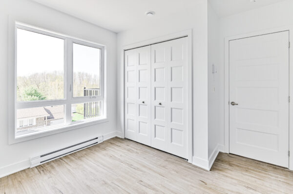Appartement lumineux avec grandes fenêtres offrant une vue dégagée. Parfait pour un logement confortable en juillet à Sainte-Julienne.
