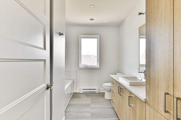 Appartement 2 chambres lumineux à Sainte-Julienne, parfait pour une famille ou un couple, avec salle de bain moderne, espace pratique et design épuré.