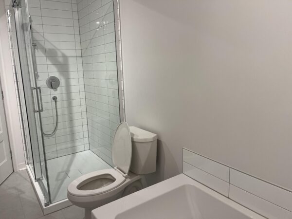 Balcon avec salle de bain moderne et douche vitrée.