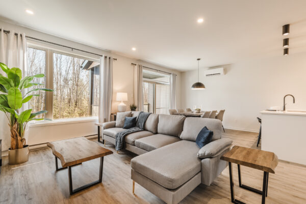 Appartement moderne et spacieux avec grandes fenêtres, salon confortable, cuisine ouverte et espace de vie convivial à Mirabel.