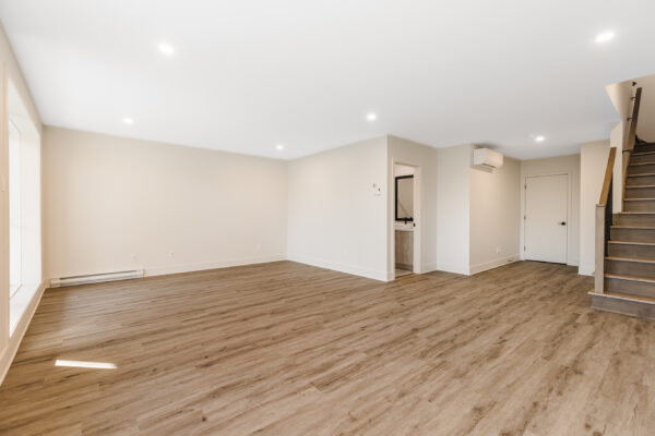 Appartement lumineux avec espace ouvert et sol en bois.