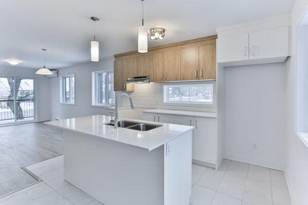 Appartement avec cuisine moderne et lumineuse à louer à Repentigny, offrant deux chambres spacieuses, un espace lumineux, et un design contemporain, idéal pour un logement confortable en juillet.