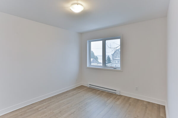 Chambre lumineuse avec fenêtre dans un appartement à louer à Repentigny, idéal pour un logement de 2 chambres. Parfait pour étudiants ou jeunes professionnels recherchant un espace confortable.