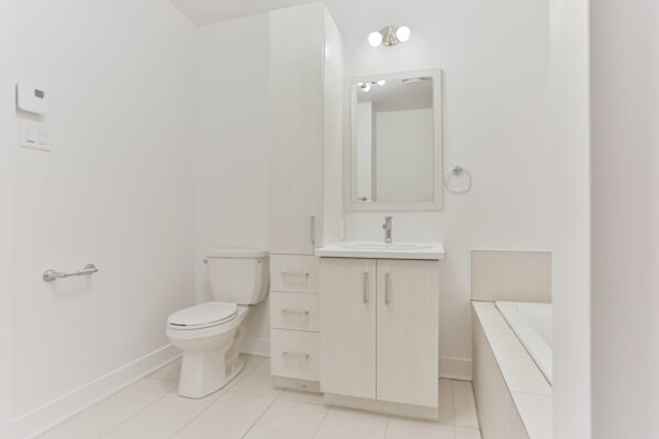 Appartement moderne avec salle de bain lumineuse et espace de rangement.