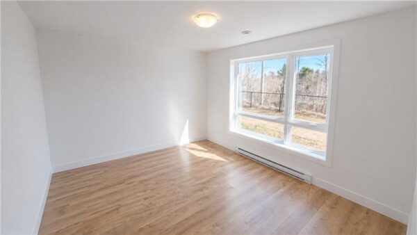 Pièce lumineuse avec deux fenêtres dans un appartement de Joliette, idéal pour un logement confortable et moderne.