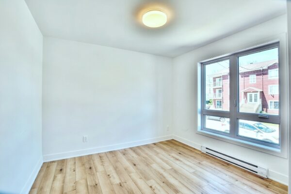 Appartement 3 chambres lumineux à Saint-Jacques, idéal pour famille ou professionnels, avec grande fenêtre offrant une vue agréable et un intérieur moderne.