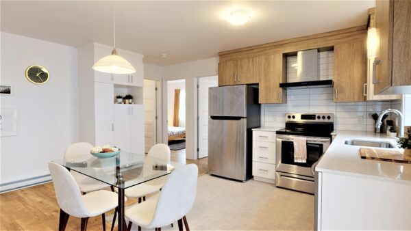 Cuisine moderne dans un appartement de 3 chambres à Saint-Charles-Borromée, avec électroménagers en acier inoxydable, espace lumineux et décoration contemporaine.