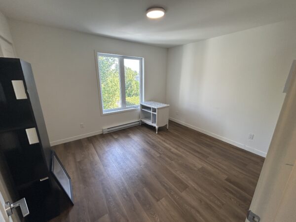 Appartement 2 chambres à louer à Saint-Jérôme, idéal pour étudiants ou jeunes professionnels, avec luminosité naturelle, parquet en bois et espace de vie confortable.