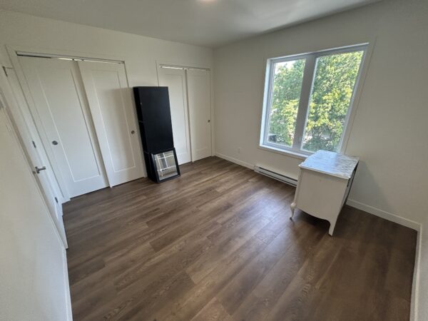 Appartement lumineux avec deux chambres à Saint-Jérôme, idéal pour famille ou professionnel. Espace moderne avec grande fenêtre offrant une vue sur la nature environnante.