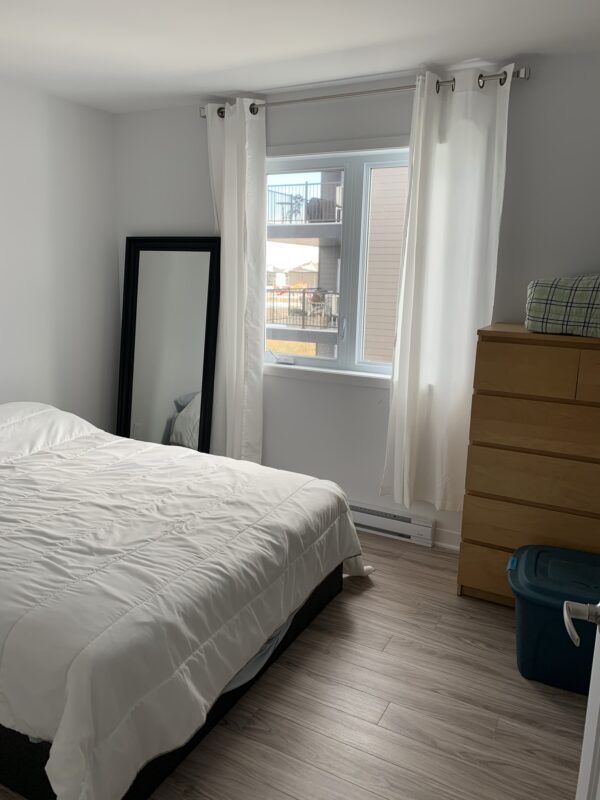 Appartement lumineux avec deux chambres à coucher, vue sur la rue Siméon-Lamarche à Mirabel, idéal pour la gestion immobilière.