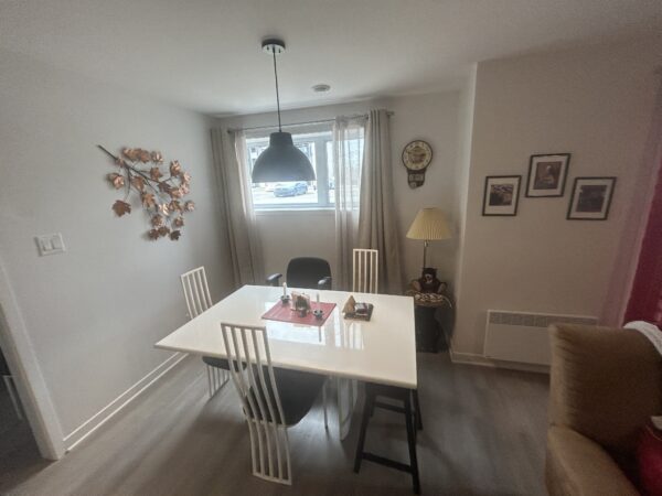 Balcon lumineux dans un appartement à Lachute, idéal pour la gestion immobilière. Confort et praticité avec espace repas, décoration moderne, et proximité des commodités.