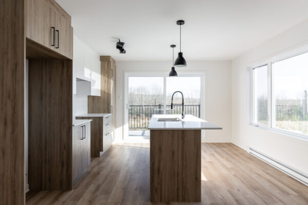 Cuisine moderne avec îlot central lumineux et vue dégagée.