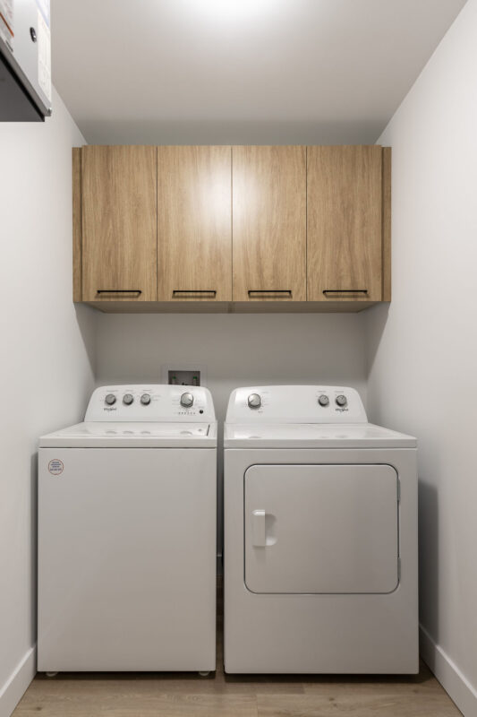 Coin buanderie avec lave-linge et sèche-linge dans un appartement de Saint-Jérôme, parfait pour la gestion efficace de la lessive.