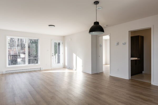 Appartement 2 chambres lumineux à Brownsburg-Chatham, idéal pour famille ou couple, avec grand espace de vie, fenêtres panoramiques et cuisine moderne.