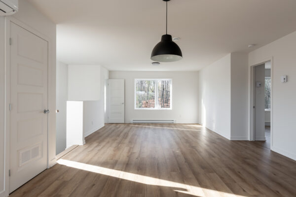 Appartement lumineux avec deux chambres à Brownsburg-Chatham, idéal pour famille ou couple, avec espace ouvert, fenêtres grandes et sol en bois.