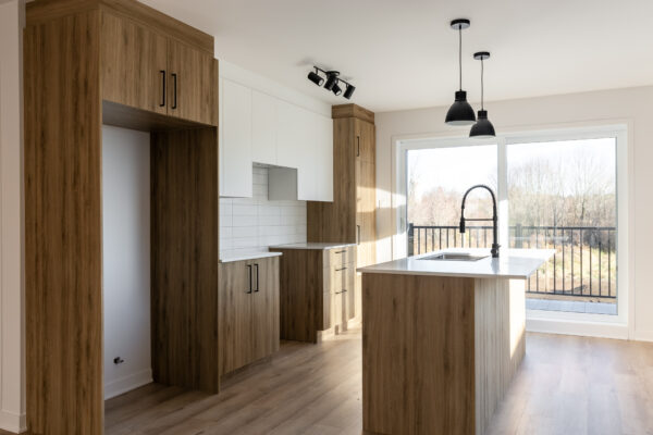 Cuisine moderne avec îlot central et grande fenêtre lumineuse.