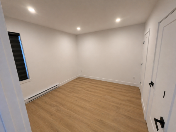 Chambre spacieuse dans un appartement de 3 chambres à Brownsburg-Chatham, idéal pour famille ou location, avec sol en bois clair et fenêtres modernes.