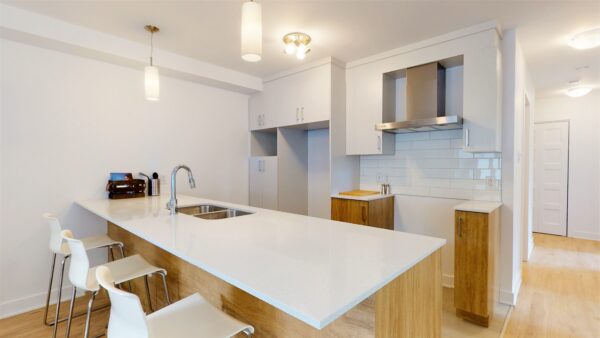 Cuisine moderne avec îlot central dans un appartement de 2 chambres à Saint-Charles-Borromée, idéal pour la gestion immobilière.