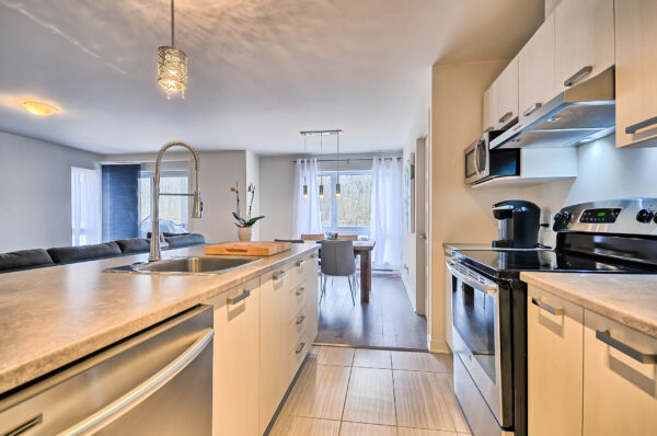 Cuisine moderne avec électroménagers dans un logement de 2 chambres à Mirabel, disponible à partir du 1er juillet, idéal pour famille ou professionnels.