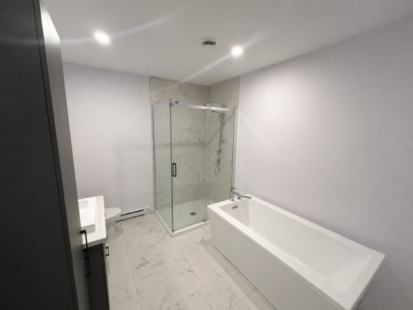 Salle de bain contemporaine avec douche en verre et baignoire dans un appartement à Brownsburg-Chatham, parfait pour la gestion immobilière.