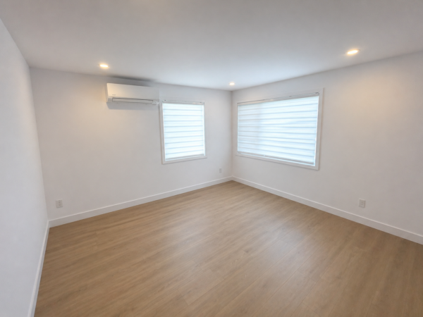 Intérieur d'un appartement moderne de 3 chambres à Brownsburg-Chatham, avec murs blancs, fenêtres lumineuses et sol en bois clair, idéal pour la gestion immobilière.