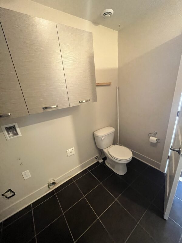 Salle de bain moderne avec toilettes et rangement.